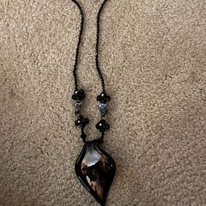 19 inch black single strand glass medallion necklace.